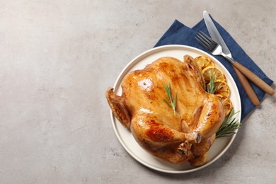 Photo of Tasty roasted chicken with rosemary and lemon served on light grey table, flat lay. Space for text