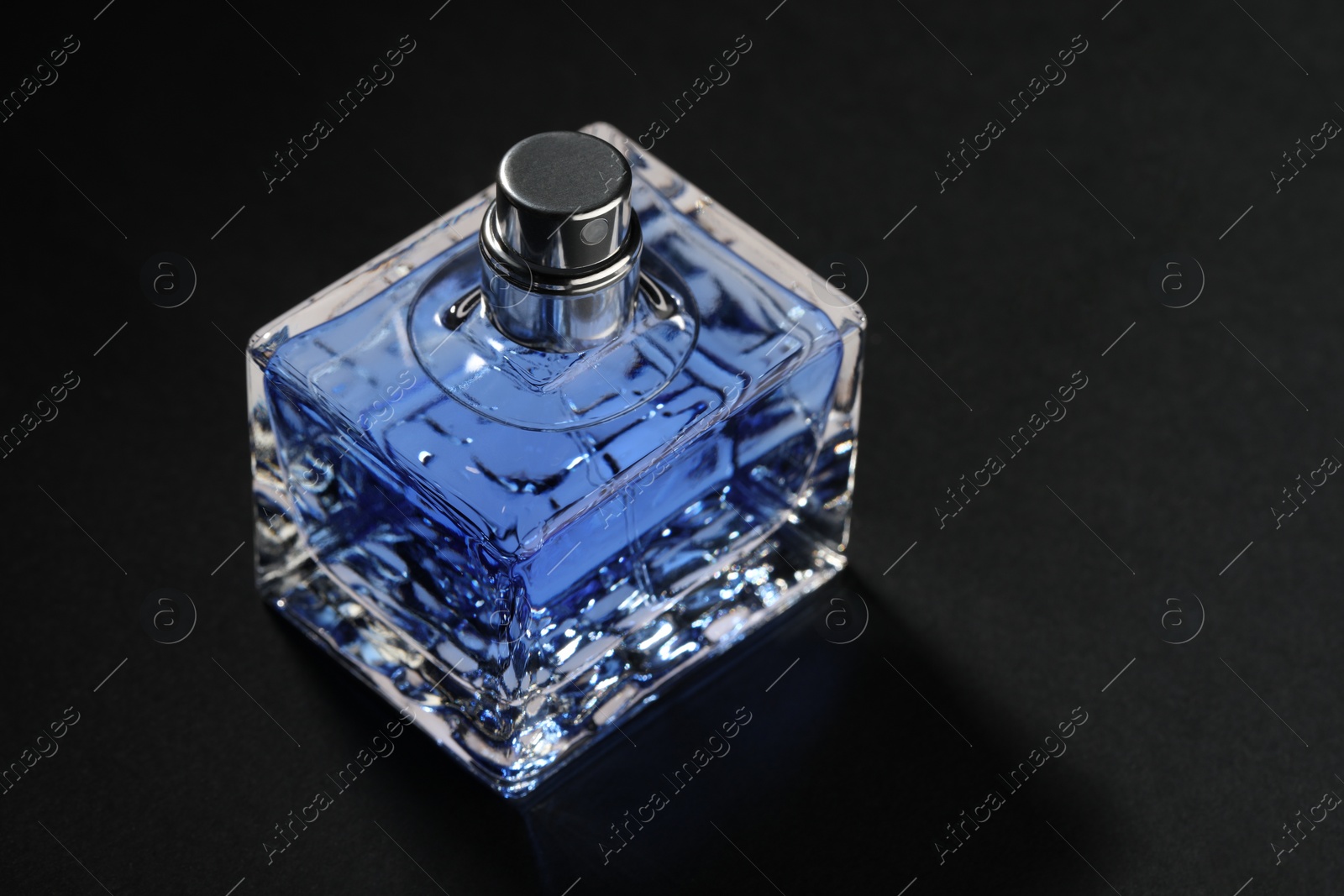 Photo of Blue men's perfume in bottle on black background, space for text