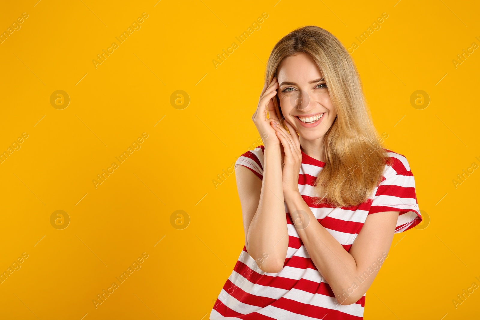 Photo of Beautiful young woman with blonde hair on yellow background. Space for text