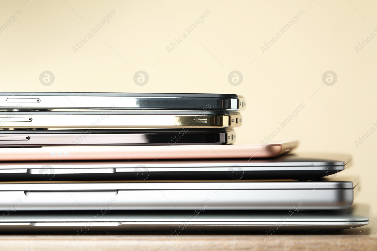 Photo of Stack of electronic devices on wooden table, closeup