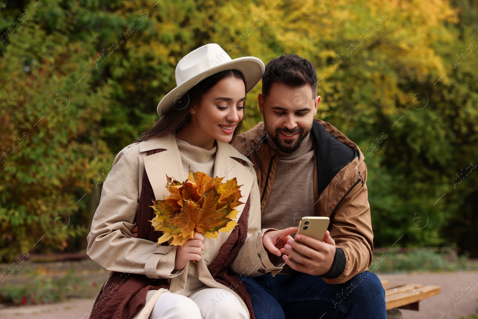 Photo of Happy young couple spending time together in autumn park