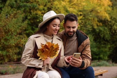 Photo of Happy young couple spending time together in autumn park