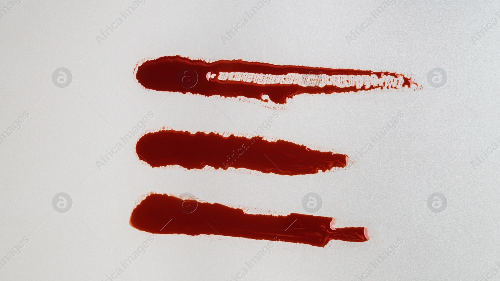 Photo of Stains of blood on grey background, top view