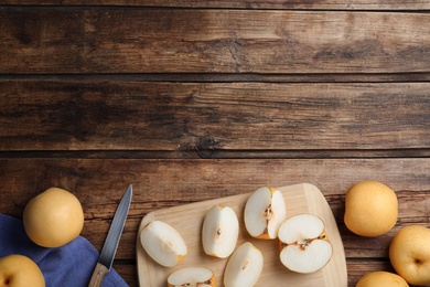 Photo of Cut and whole apple pears on wooden table, flat lay. Space for text