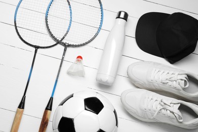 Different sports equipment on white wooden table, flat lay