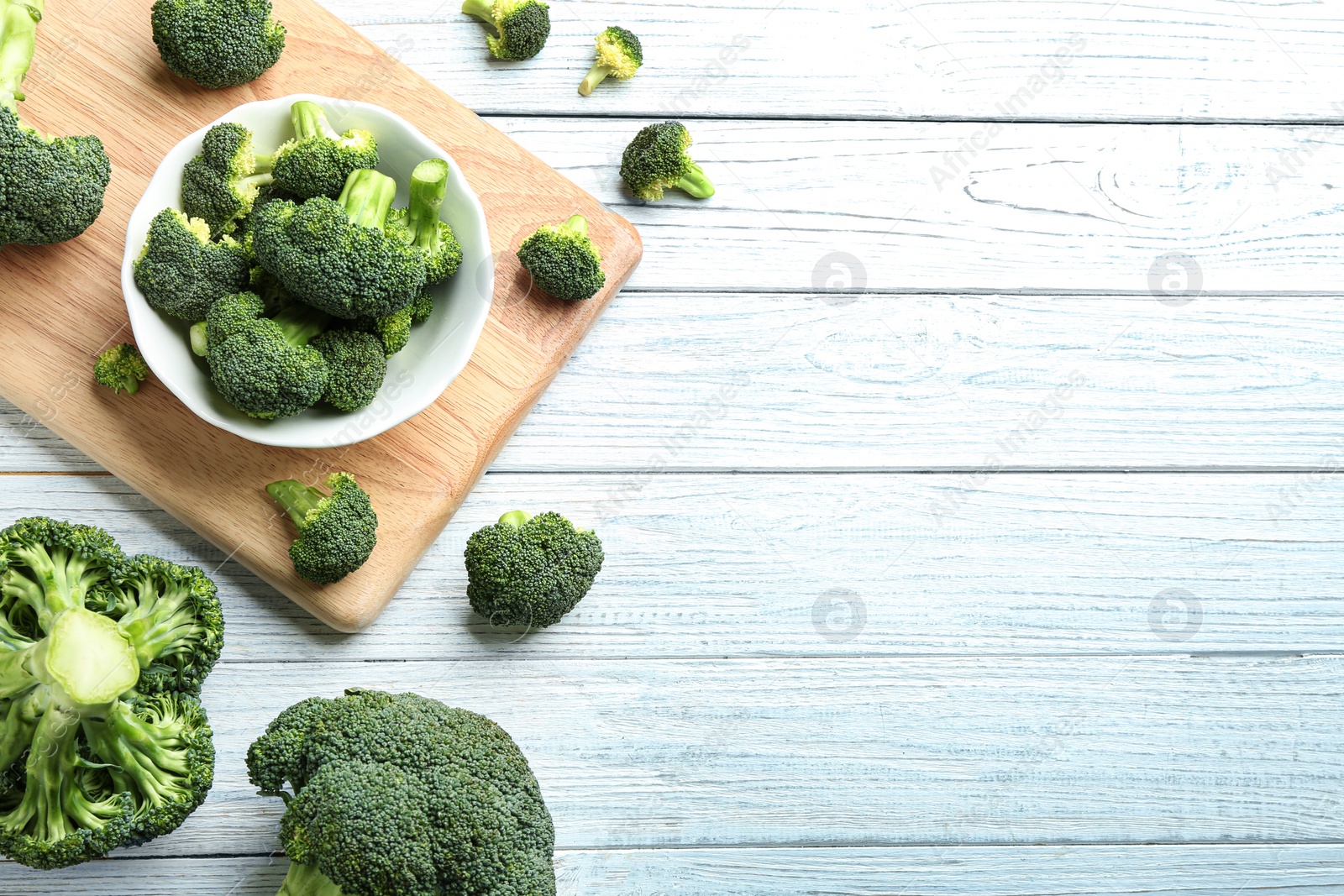 Photo of Flat lay composition of fresh green broccoli on white wooden table, space for text