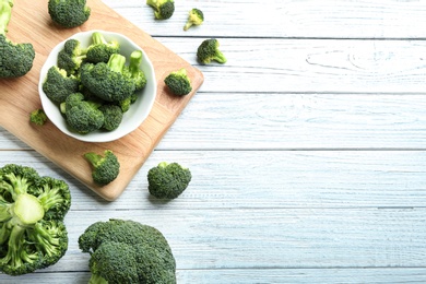 Photo of Flat lay composition of fresh green broccoli on white wooden table, space for text