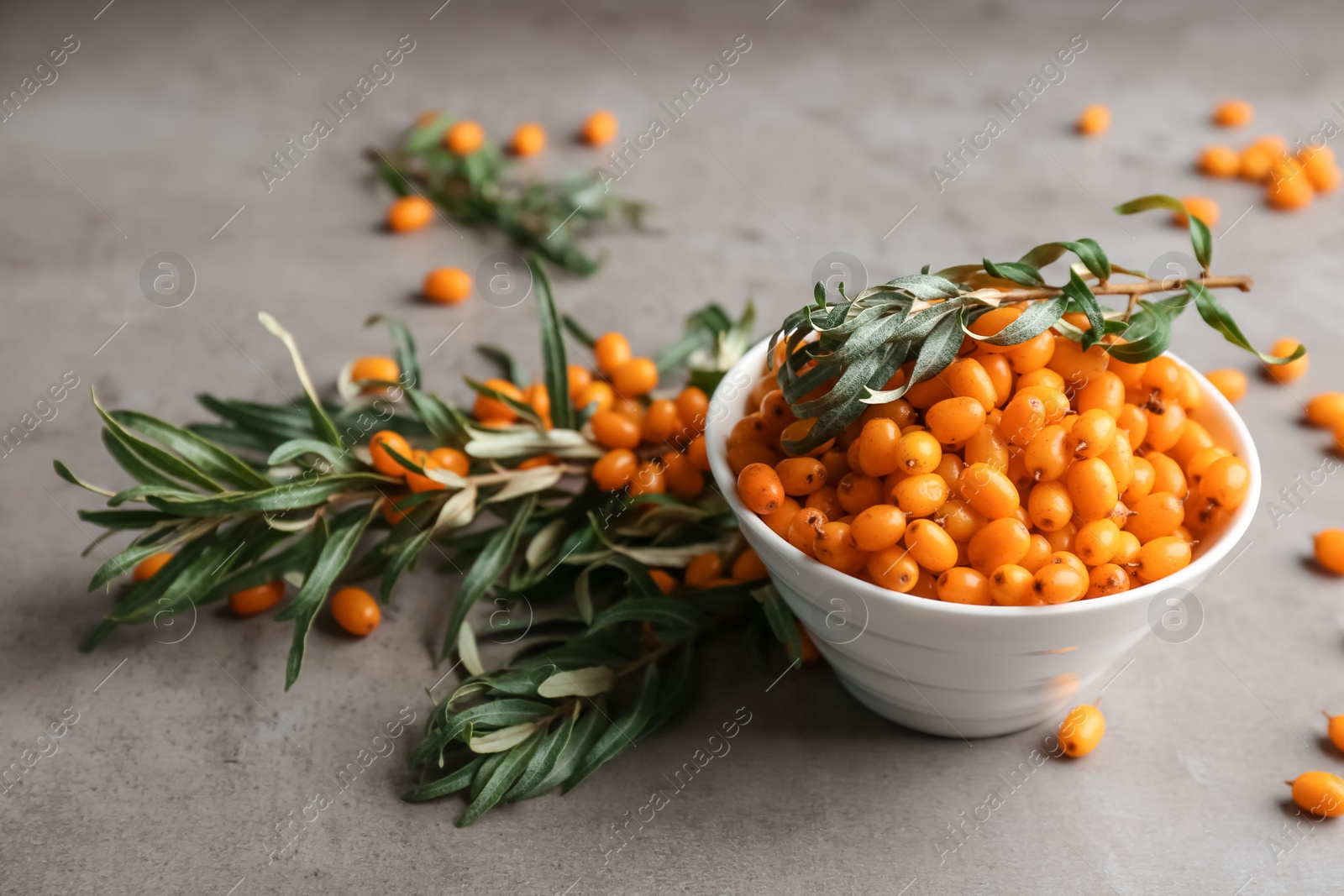 Photo of Fresh ripe sea buckthorn in bowl on grey table