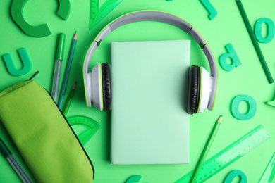 Photo of Flat lay composition with book and stationery on light green background