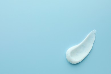 Photo of Sample of face scrub on light blue background, top view. Space for text