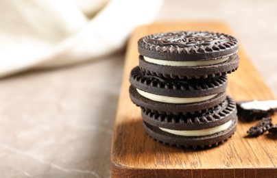 Photo of Board with chocolate cookies on table. Space for text