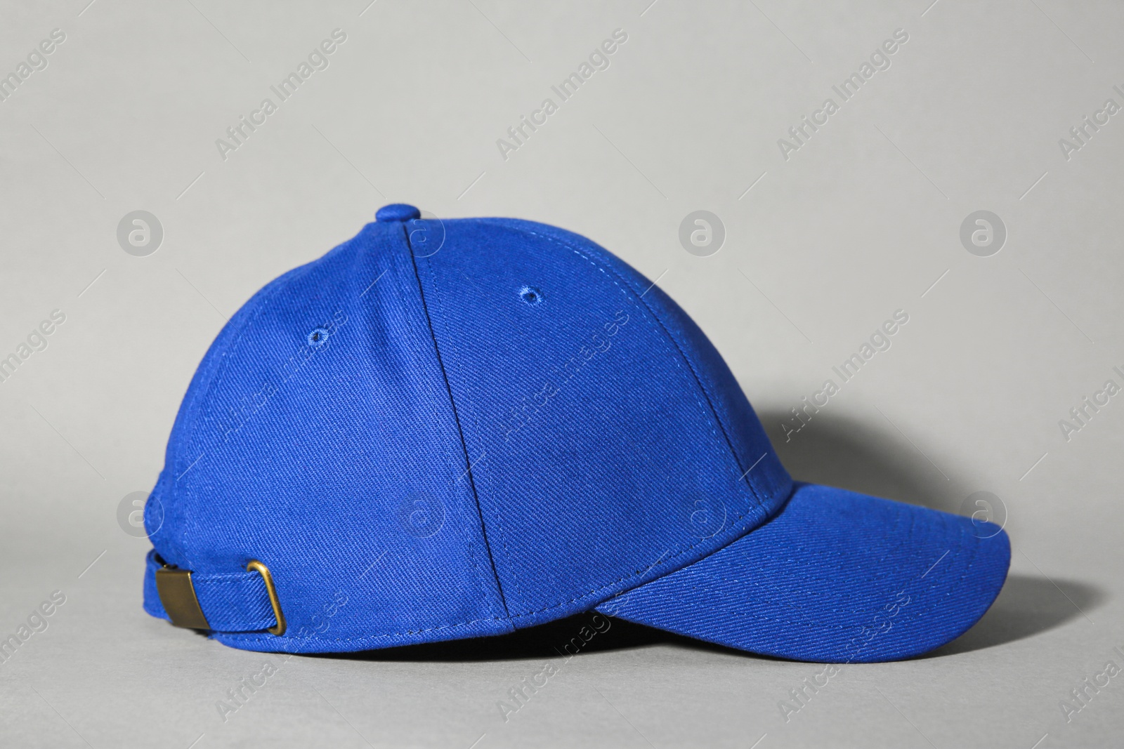 Photo of Stylish blue baseball cap on grey background