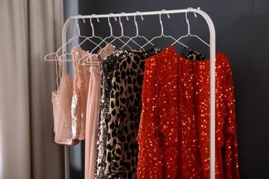 Photo of Rack with collection of beautiful festive clothes indoors