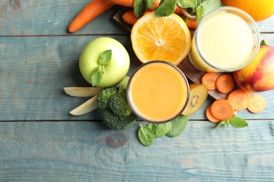 Photo of Glasses of delicious juices and fresh ingredients on blue wooden table, flat lay