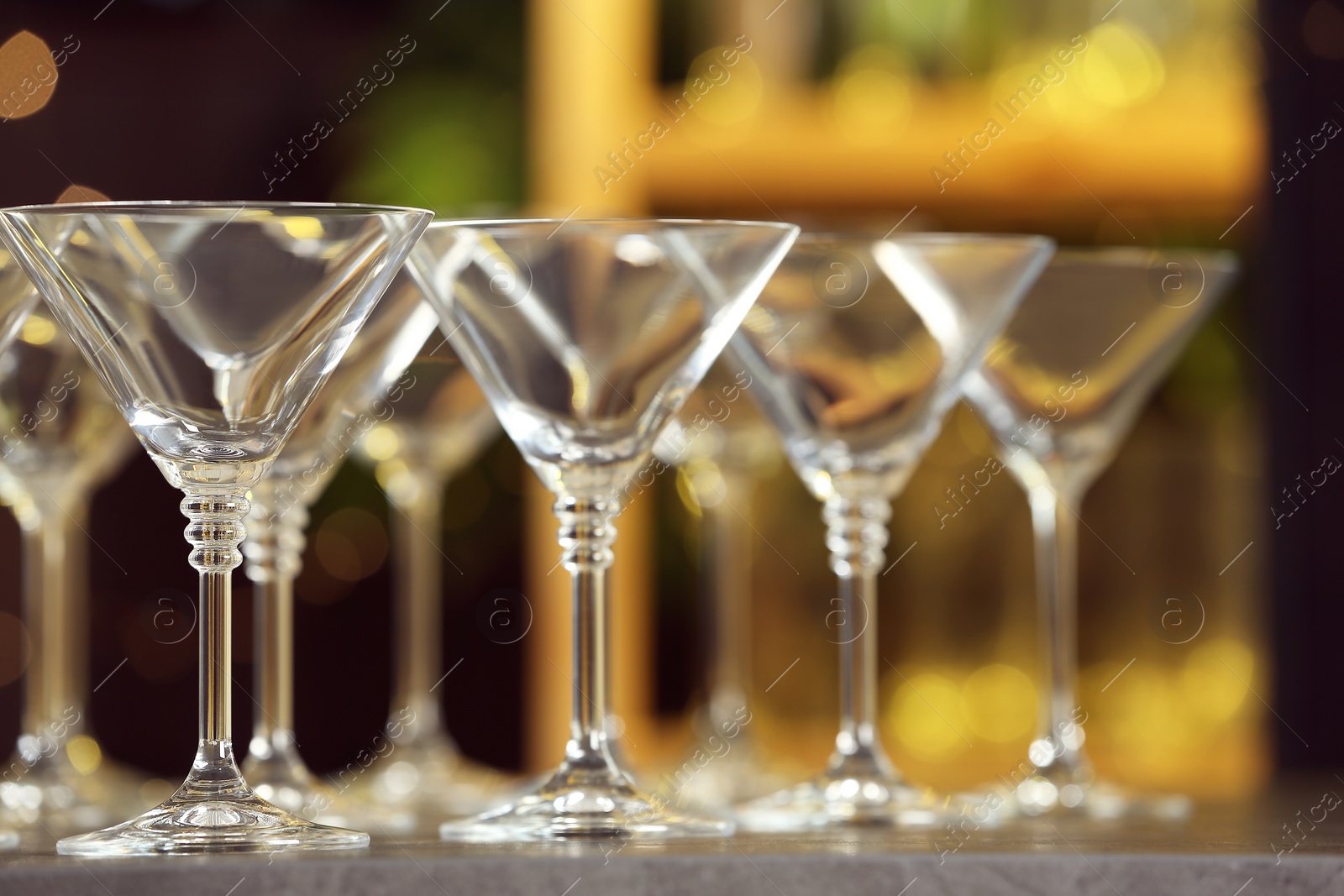 Photo of Empty martini glasses on table against blurred background