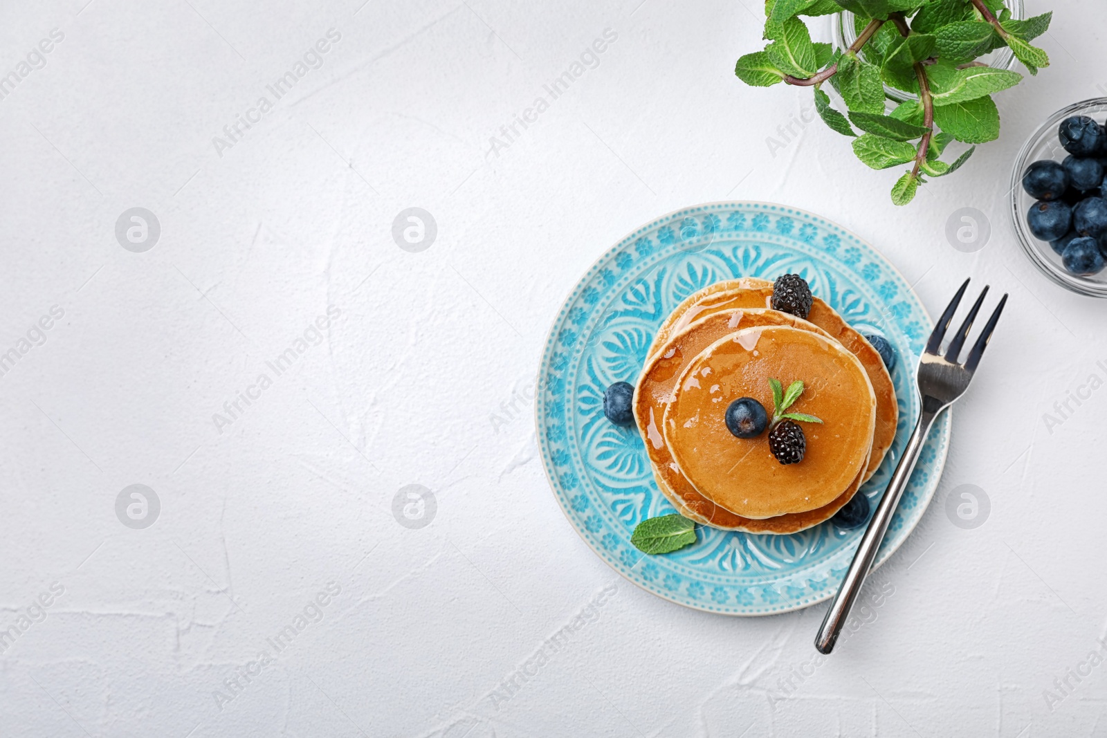 Photo of Flat lay composition with tasty pancakes on light background