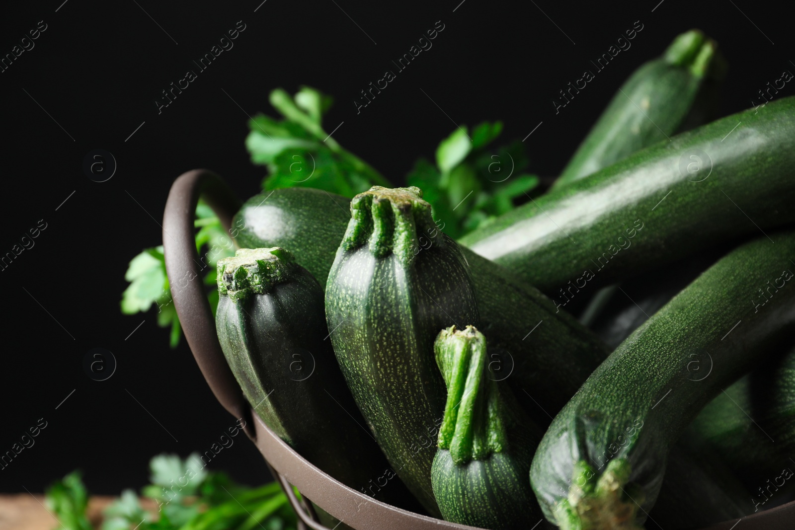 Photo of Basket with green zucchinis on black background, closeup