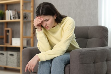 Photo of Overwhelmed woman sitting in armchair at home