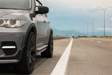 Photo of Grey modern car parked on asphalt road