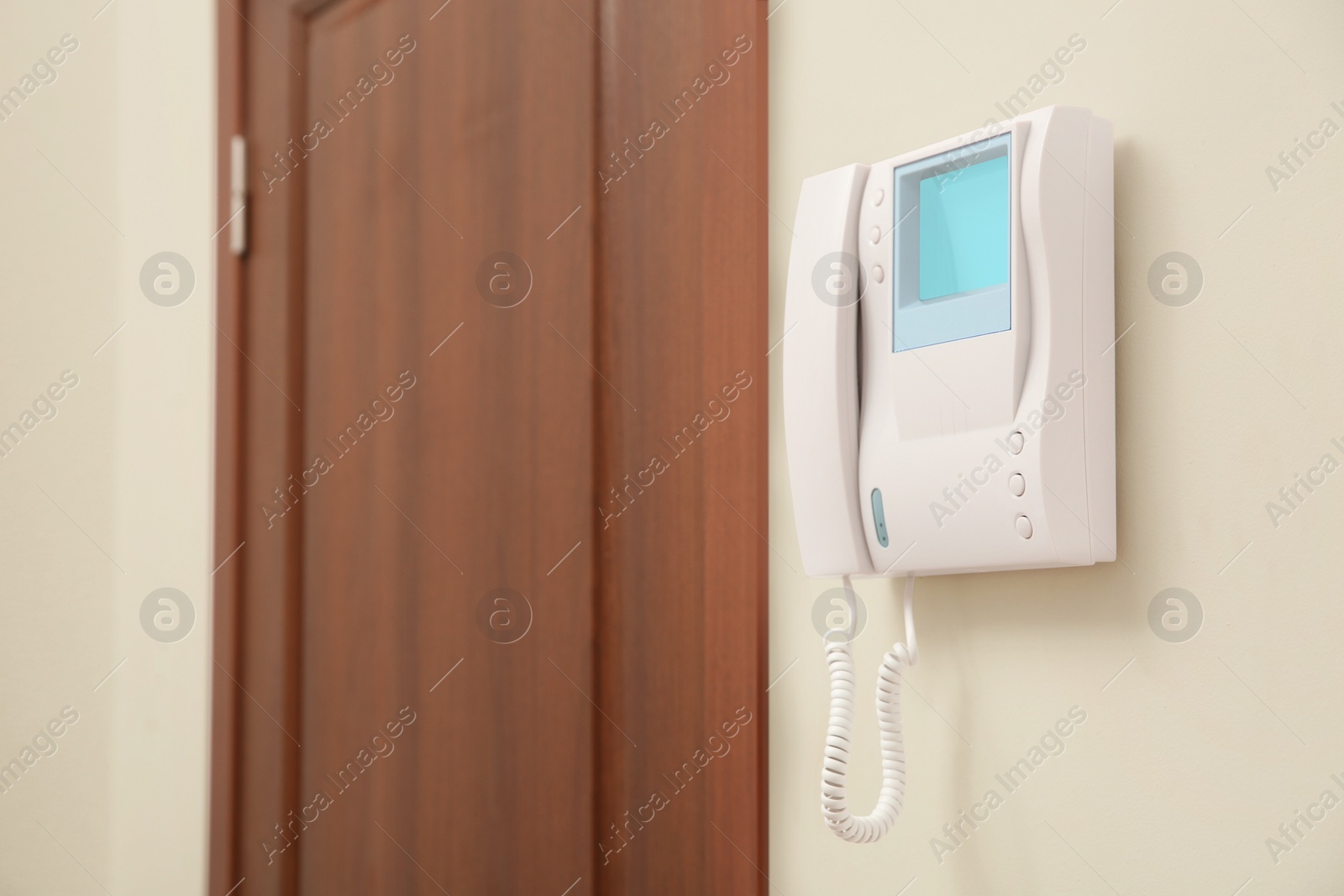 Photo of Modern intercom system with handset on white wall indoors, space for text