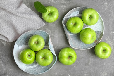 Composition with fresh green apples on grey table, top view