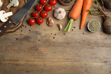Photo of Flat lay composition with ingredients for cooking on wooden table. Space for text
