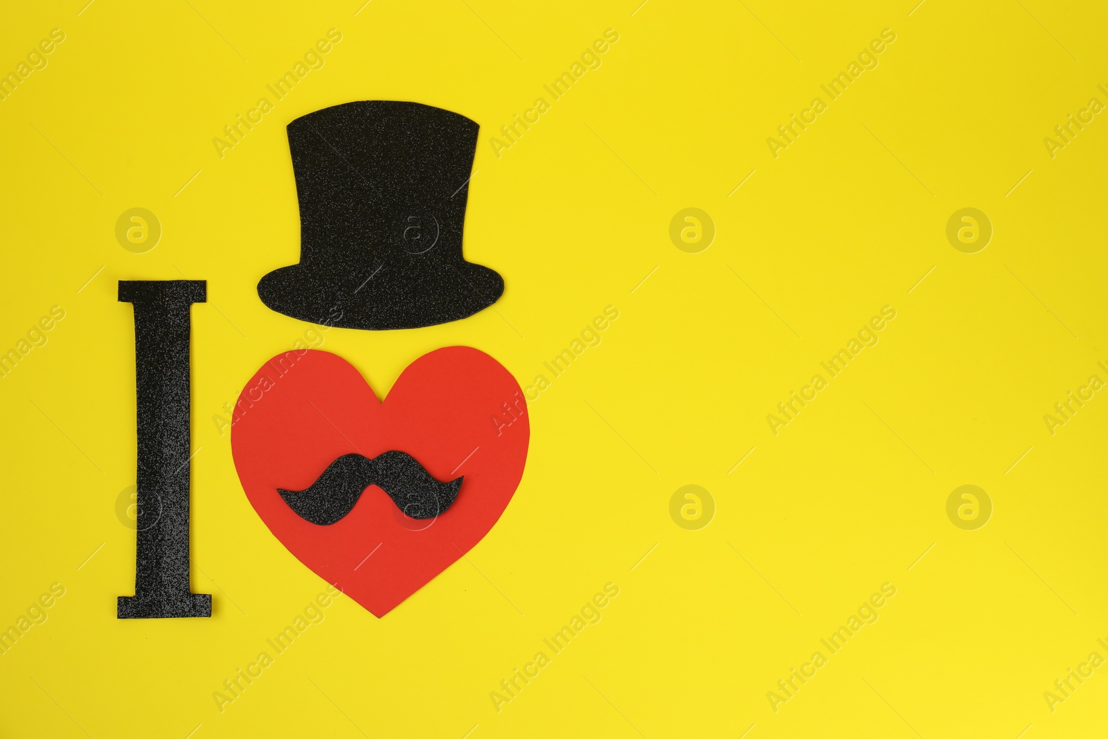 Photo of I Love Mustache. Flat lay composition of paper hat and heart on yellow background. Space for text