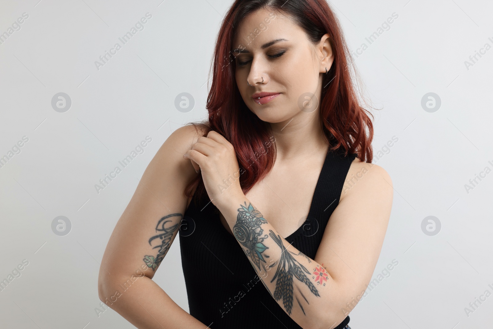 Photo of Portrait of beautiful tattooed woman on gray background