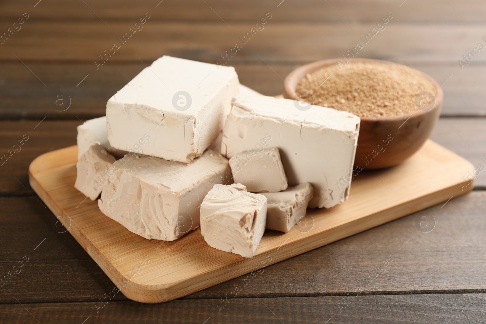 Photo of Compressed and granulated yeast on wooden table