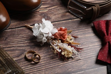 Wedding stuff. Composition with stylish boutonniere on wooden background, closeup