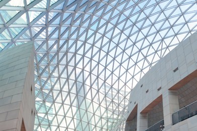 Modern mall with glass ceiling, low angle view