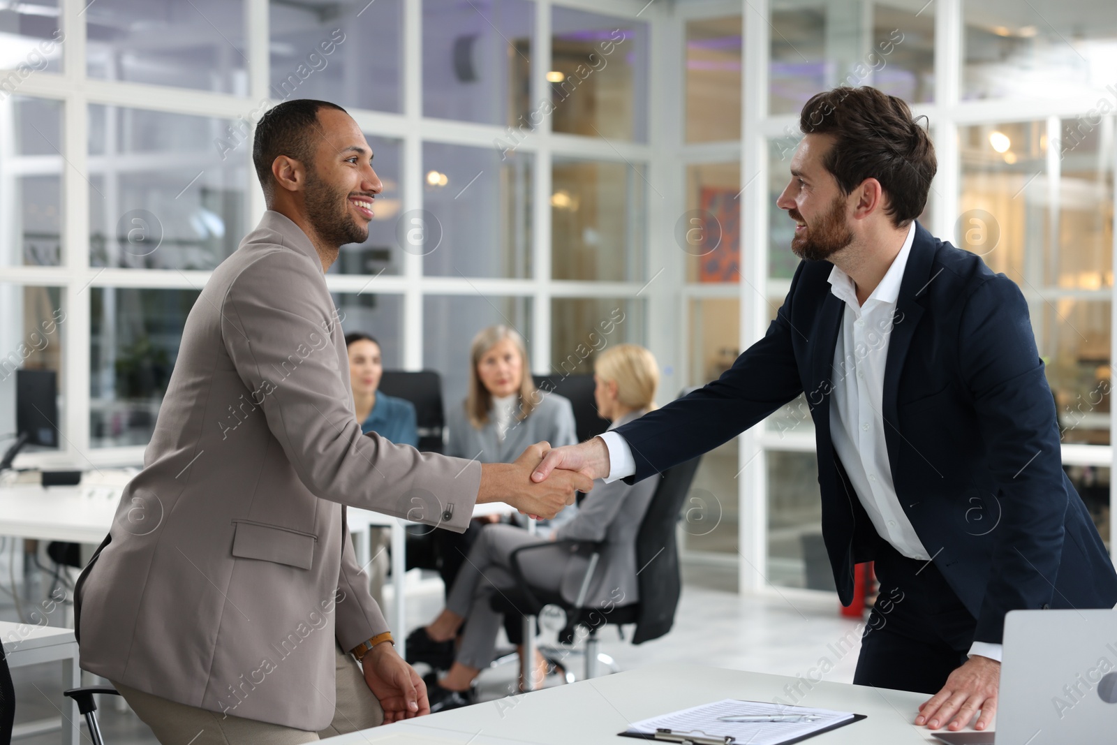 Photo of Lawyer shaking hands with client in office, selective focus