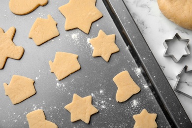 Photo of Raw Christmas cookies on baking tray, top view