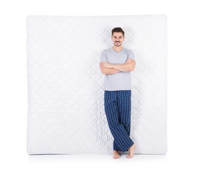 Young man with comfortable mattress isolated on white