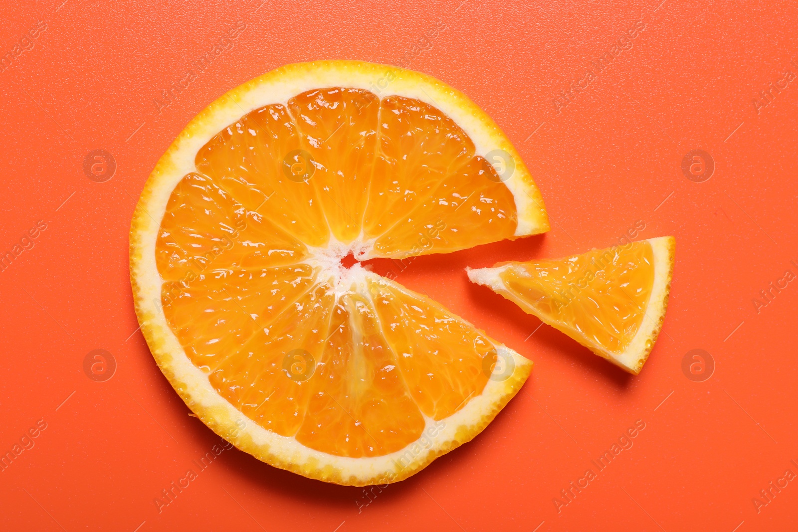 Photo of Slices of juicy orange on terracotta background, top view