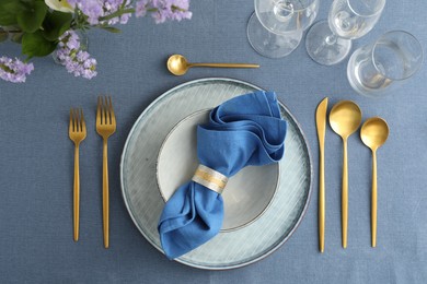 Photo of Stylish setting with cutlery, dishes, napkin, glasses and floral decor on table, flat lay