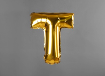 Photo of Golden letter T balloon on grey background