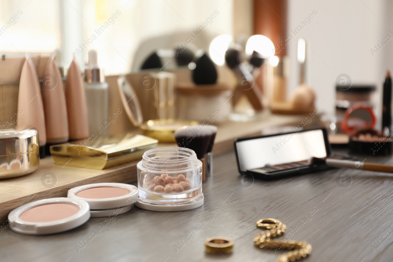 Photo of Many different cosmetic products on dressing table indoors