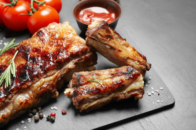 Delicious grilled ribs on black table, closeup