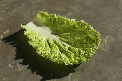 Photo of Fresh Chinese cabbage leaf on gray textured table