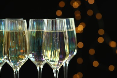 Glasses of champagne against blurred lights, closeup