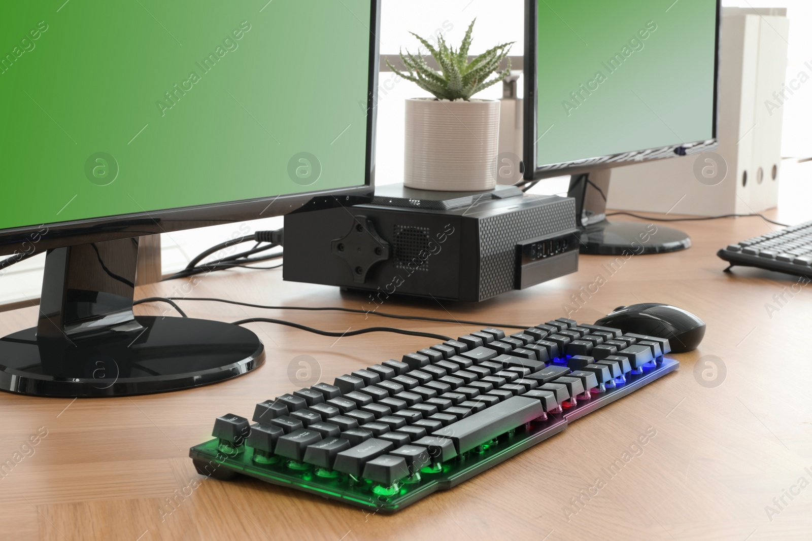 Photo of Modern computer and RGB keyboard on wooden table indoors