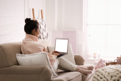 Photo of Woman with laptop relaxing at home. Cozy atmosphere