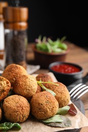 Delicious falafel balls with herbs on board, closeup. Space for text