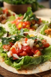 Photo of Delicious tacos with vegetables and meat on table, closeup