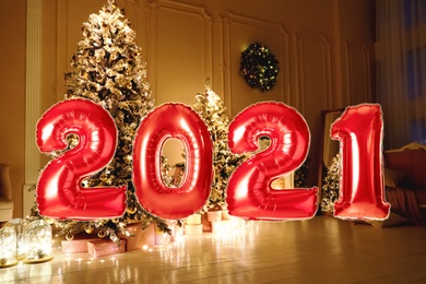 Image of Red foil 2021 balloons in festive room interior 