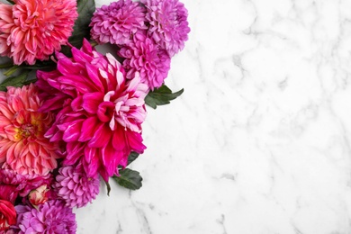 Photo of Beautiful dahlia flowers on white marble background, flat lay. Space for text
