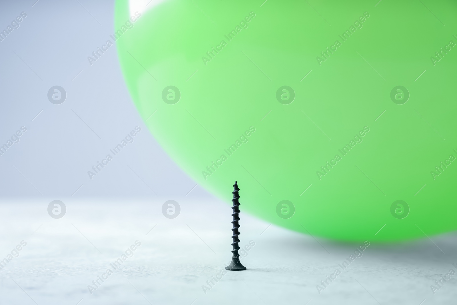 Photo of Color balloon and nail on table against white background, space for text