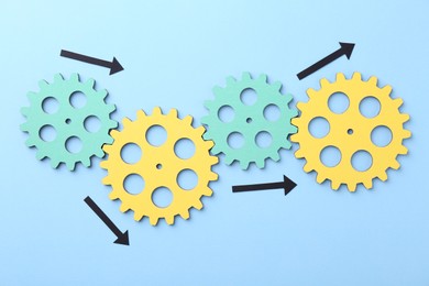 Business process organization and optimization. Scheme with wooden figures and arrows on light blue background, top view