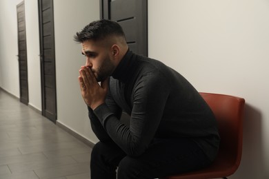 Portrait of sad young man in hall